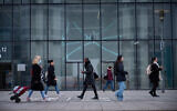 Des travailleurs passent devant un immeuble de bureaux à la fin de la journée de travail dans le quartier d'affaires de La Défense, à Paris, le 8 novembre 2024. (Photo de Kiran RIDLEY et Kiran RIDLEY / AFP)