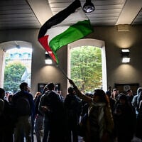 Un manifestant brandit un drapeau palestinien lors d'un rassemblement contre la visite du président de l'Assemblée nationale française à l'Université Lyon 3, à Lyon, le 8 novembre 2024. Le 6 octobre, sur le média français BFMTV, le président de l'Assemblée nationale française a déclaré qu'« Israël ne doit pas être désarmé », en réaction aux déclarations du président français appelant à l'arrêt des livraisons d'armes pour les combats à Gaza. (Photo OLIVIER CHASSIGNOLE / AFP)