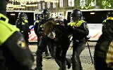 Des policiers arrêtent un manifestant lors d'une manifestation pro-palestinienne non autorisée sur la place du Dam à Amsterdam, le 13 novembre 2024. (Crédit : Nick Gammon / AFP)