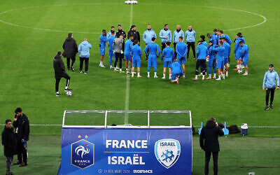 L'entraîneur principal d'Israël, Ran Ben Shimon (au centre), s'entretenant avec ses joueurs lors d'une séance d'entraînement au Stade de France, à Saint-Denis, au nord de Paris, le 13 novembre 2024, à la veille du match de football de la Ligue des nations de l'UEFA, groupe A2, entre la France et Israël. (Crédit : Franck Fife/AFP)