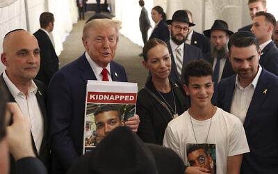 Donald Trump, alors candidat républicain à l'élection présidentielle, posant pour des photos avec des membres de la famille d'Edan Alexander, un otage détenu par le Hamas, après avoir visité la tombe du rabbin Menachem Mendel Schneerson, à New York, le 7 octobre 2024. (Crédit : Yuki Iwamura/AP)