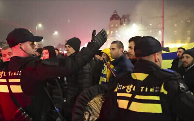 Sur cette image tirée d'une vidéo, on voit la police escorter des supporters du Maccabi Tel Aviv jusqu'à la station de métro pour aller au stade de l'Ajax, suite à un défilé de manifestants anti-Israël non loin du stade, à Amsterdam, aux Pays-Bas, le 7 novembre 2024. (Crédit : AP Photo InterVision)