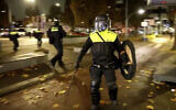 Sur cette image tirée d'une vidéo, des policiers patrouillent en tenue anti-émeute dans les rues d'Amsterdam, le 11 novembre 2024, alors que la ville est confrontée à des tensions suite à des violences antisémites généralisées la semaine précédente. (Crédit : AP Photo)