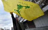 Photo d'illustration : Une femme brandissant un drapeau du Hezbollah, fêtant le cessez-le-feu entre le Hezbollah et Israël, à Tyr, au sud du Liban, le 27 novembre 2024. (Crédit : Hussein Malla/AP)