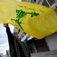 Photo d'illustration : Une femme brandissant un drapeau du Hezbollah, fêtant le cessez-le-feu entre le Hezbollah et Israël, à Tyr, au sud du Liban, le 27 novembre 2024. (Crédit : Hussein Malla/AP)