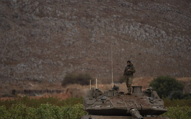 Un soldat israélien se tient sur le toit d'un char dans une zone proche de la frontière israélo-libanaise, vue du nord d'Israël le 27 novembre 2024. (Crédit : AP Photo/Leo Correa)