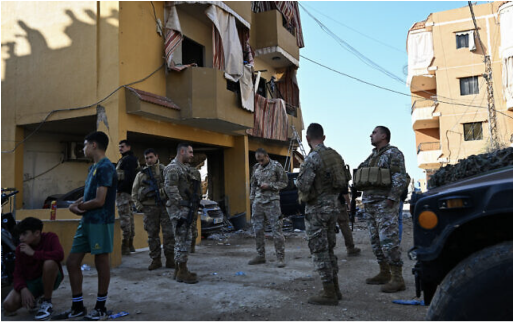 Des soldats libanais à côté d'un bâtiment endommagé sur le site d'une frappe israélienne un jour plus tôt sur un immeuble, dans la ville de Barja, au Liban, le 6 novembre 2024. (Crédit : Joseph Eid/AFP)