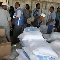 Des Palestiniens perçoivent de l'aide humanitaire dans un centre de distribution des Nations Unies (UNRWA) dans le camp de réfugiés de Rafah, dans le sud de la bande de Gaza, le 31 juillet 2014 (crédit photo : Abed Rahim Khatib/Flash90)