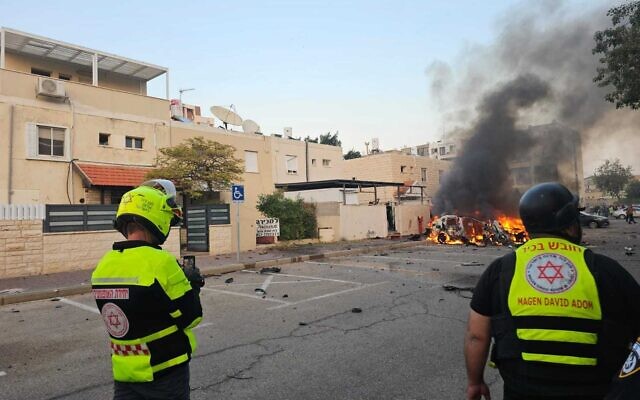 Des secouristes après que des voitures ont pris feu à la suite d'une attaque à la roquette, à Kiryat Yam, le 7 novembre 2024. (Crédit : MDA)