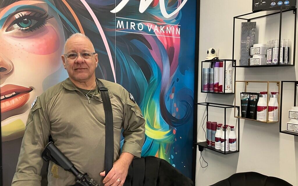 Miro Vahknin, dans son salon de coiffure, membre de l'équipe de première intervention du kibboutz Rosh HaNikra, à Nahariya. (Crédit : Diana Bletter/Times of Israel)