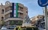 Un grand drapeau de l'opposition syrienne est suspendu sur la place centrale de Majdal Shams, le 9 décembre 2024. (Crédit : Lindy Barnett)