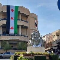 Un grand drapeau de l'opposition syrienne est suspendu sur la place centrale de Majdal Shams, le 9 décembre 2024. (Crédit : Lindy Barnett)