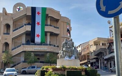 Un grand drapeau de l'opposition syrienne est suspendu sur la place centrale de Majdal Shams, le 9 décembre 2024. (Crédit : Lindy Barnett)