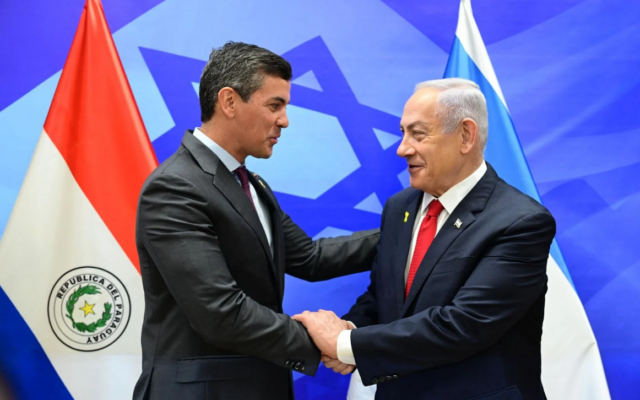 Le Premier ministre Benjamin Netanyahu (à droite) serre la main du président paraguayen en visite, Santiago Peña, lors d'une cérémonie de réouverture de l'ambassade du Paraguay à Jérusalem, le 12 décembre 2024. (Crédit : Amos Ben Gershom/GPO)