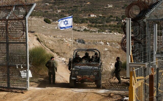 Un véhicule militaire israélien franchissant la clôture, revenant de la zone tampon avec la Syrie, près du village druze de Majdal Shams, sur le plateau du Golan, le 10 décembre 2024. (Crédit : Jalaa Marey/AFP)