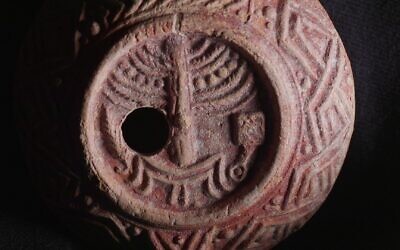 Une rare lampe à huile vieille de 1 700 ans, décorée de la ménorah du Temple, découverte à Jérusalem, sur une image publiée le 26 décembre 2024. (Crédit : Emil Aladjem/Autorité israélienne des Antiquités)