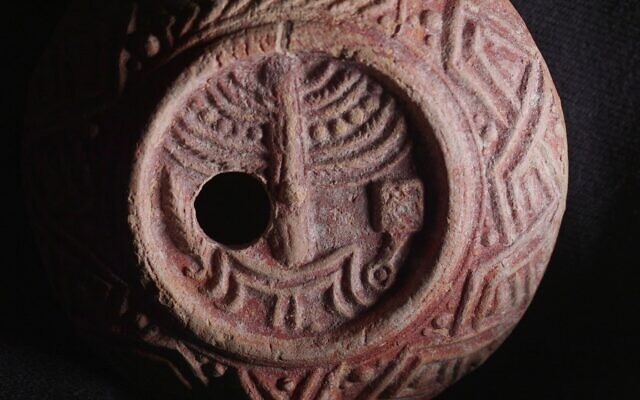 Une rare lampe à huile vieille de 1 700 ans, décorée de la ménorah du Temple, découverte à Jérusalem, sur une image publiée le 26 décembre 2024. (Crédit : Emil Aladjem/Autorité israélienne des Antiquités)