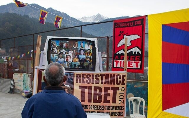 Un militant se recueille devant des portraits de prisonniers politiques tibétains libérés en 2015 des prisons chinoises lors d'un événement organisé par Students for a Free Tibet à Dharamshala, en Inde, le 26 décembre 2015. (Crédit : Ashwini Bhatia/AP)