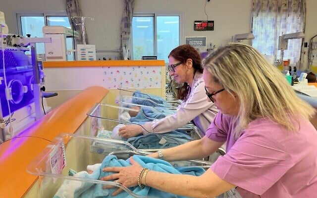 Debbie Cohen, infirmière en chef du service des nouveau-nés, et Amira Morad, infirmière du personnel, s’occupent des nourrissons à l'hôpital de Galilée le 22 décembre 2024. (Crédit : Diana Bletter/Times of Israel)