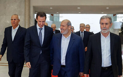 Photo d'illustration : Cette photo diffusée par la présidence syrienne montre Le dictateur syrien de l'époque, Bashar el-Assad (2e à gauche), recevant le chef du Jihad islamique palestinien, Ziad al-Nakhala (à droite), le chef des relations arabes du Hamas, Khalil al-Hayya (2e à droite), et le secrétaire général du Front populaire pour la libération de la Palestine (FPLP), Talal Naji (à gauche), dans la capitale Damas, le 19 octobre 2022. (Crédit : STRINGER / Syrian Presidency Facebook page/AFP)