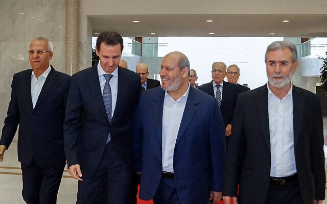 Photo d'illustration : Cette photo diffusée par la présidence syrienne montre Le dictateur syrien de l'époque, Bashar el-Assad (2e à gauche), recevant le chef du Jihad islamique palestinien, Ziad al-Nakhala (à droite), le chef des relations arabes du Hamas, Khalil al-Hayya (2e à droite), et le secrétaire général du Front populaire pour la libération de la Palestine (FPLP), Talal Naji (à gauche), dans la capitale Damas, le 19 octobre 2022. (Crédit : STRINGER / Syrian Presidency Facebook page/AFP)