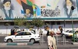 Des Iraniens traversant une route sous un panneau d'affichage portant les portraits du défunt fondateur de la République islamique, l'ayatollah Ruhollah Khomeini (à droite), et de l'actuel guide suprême, l'ayatollah Ali Khamenei, dans la capitale Téhéran, le 27 août 2024. (Crédit : Atta Kenare/AFP)