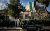 Un drapeau de l'opposition syrienne déployé à l'ambassade de Syrie, à Athènes, le 8 décembre 2024. (Crédit : Angelos Tzortzinis/AFP)