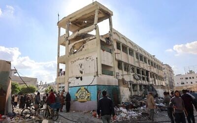 Des résidents inspectent les dégâts causés par une frappe israélienne sur l'école Al-Majda Wasila de l'UNWRA, qui abrite des Palestiniens déplacés à Gaza City,  le 14 décembre 2024. (Crédit : Omar Al-Qattaa/AFP)