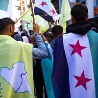 Photo d'illustration : Des Kurdes syriens brandissant des drapeaux de l'époque de l'indépendance lors d'une manifestation de soutien aux Forces démocratiques syriennes, soutenues par les États-Unis et dirigées par les Kurdes, dans la ville de Qamishli, dans le nord-est du pays, le 19 décembre 2024. (Crédit : Delil Souleiman/AFP)