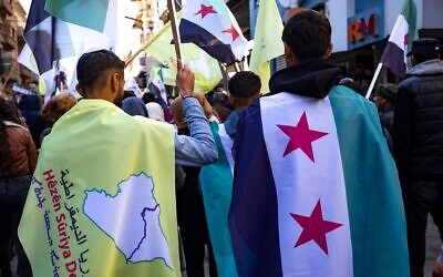 Photo d'illustration : Des Kurdes syriens brandissant des drapeaux de l'époque de l'indépendance lors d'une manifestation de soutien aux Forces démocratiques syriennes, soutenues par les États-Unis et dirigées par les Kurdes, dans la ville de Qamishli, dans le nord-est du pays, le 19 décembre 2024. (Crédit : Delil Souleiman/AFP)