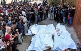 Des hommes se recueillant devant les corps des victimes tuées lors d'une frappe israélienne, à l'extérieur de la morgue du complexe hospitalier Nasser, à Khan Younès, dans le sud de la bande de Gaza, le 23 décembre 2024. (Crédit : Bashar Taleb/AFP)