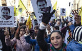 Des manifestants brandissent des drapeaux jaunes et des portraits montrant le visage d'Abdullah Ocalan, le leader du Parti des travailleurs du Kurdistan (PKK) - emprisonné en Turquie depuis 1999 - lors d'une manifestation demandant sa libération, dans la ville à majorité kurde de Qamishli, dans le nord-est de la Syrie, le 15 février 2023. (Crédit : Delil SOULEIMAN / AFP)