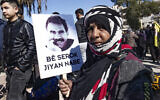 Une manifestante brandissant une pancarte portant le portrait d'Abdullah Ocalan, le chef du Parti des travailleurs du Kurdistan (PKK) - emprisonné en Turquie depuis 1999 - lors d'une manifestation réclamant sa libération, dans la ville à majorité kurde de Qamishli, dans le nord-est de la Syrie, le 15 février 2023. (Crédit : Delil Souleiman/AFP)