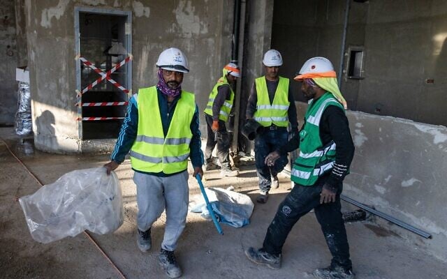 Des constructeurs indiens travaillant sur un site de construction, à Tel Aviv, le 23 décembre 2024. (Crédit : Menahem Kahana/AFP)