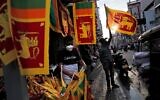 Des marchands ambulants sri-lankais vendant des drapeaux nationaux à l'approche du 73e anniversaire de l'indépendance du pays, à Colombo, au Sri Lanka, le 2 février 2021. (Crédit : Eranga Jayawardena/AP)