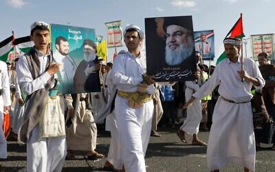 Des partisans des Houthis brandissent une affiche du défunt chef du Hezbollah, Hassan Nasrallah, un an jour pour jour après le début de la guerre dans la bande de Gaza, à Sanaa, au Yémen, le 7 octobre 2024. (Crédit : AP/Osamah Abdulrahman)