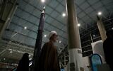 Un religieux passant devant des missiles iraniens de fabrication nationale alors qu'il visite le parc aérospatial national du Corps des Gardiens de la Révolution islamique (CGRI), le bras armé de l'Iran, juste à l'extérieur de Téhéran, en Iran, le 15 novembre 2024. (Crédit : Vahid Salemi/AP)
