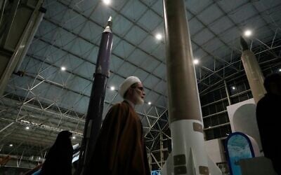 Un religieux passant devant des missiles iraniens de fabrication nationale alors qu'il visite le parc aérospatial national du Corps des Gardiens de la Révolution islamique (CGRI), le bras armé de l'Iran, juste à l'extérieur de Téhéran, en Iran, le 15 novembre 2024. (Crédit : Vahid Salemi/AP)