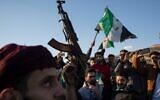 Un Syrien brandissant une arme lors d'une manifestation de célébration après la première prière du vendredi depuis l'éviction de Bashar el-Assad, sur la place centrale de Damas, en Syrie, le 13 décembre 2024. (Crédit: Leo Correa/AP)
