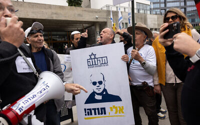 Des personnes manifestant en soutien à Eli Feldstein et au soldat réserviste de l’armée israélienne  accusé d'avoir divulgué des documents classifiés, devant le tribunal de Tel Aviv, le 27 novembre 2024. (Crédit : Miriam Alster/Flash90)