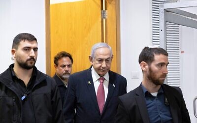 Le Premier ministre Benjamin Netanyahu arrivant dans la salle d'audience du tribunal de Tel Aviv où il témoigne dans son procès pénal, le 24 décembre 2024. (Crédit : Moti Milrod/POOL)