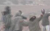 Des résidents d’implantations filmés en train de jeter des pierres à des Palestiniens après avoir fait une descente dans le village de Susya, le 21 décembre 2024. (Crédit : Capture d'écran/X)