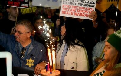 Einav Zangauker entourée de manifestants pour marquer le 25e anniversaire de son fils Matan, le deuxième en captivité dans les geôles du Hamas, à Tel Aviv, le 18 décembre 2024. (Crédit : Danor Aharon/Mouvement de protestation pour la démocratie)