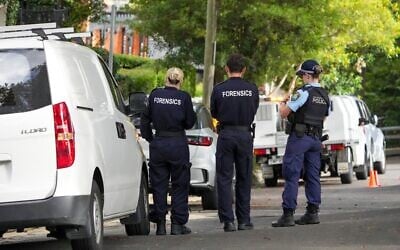La police se tient près de maisons vandalisées avec des slogans anti-Israël dans la banlieue de Sydney de Woollahra, en Australie, le 11 décembre 2024. Illustration (Crédit : Mark Baker/AP)