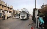 Des hommes montent la garde sur le trajet du camion chargé d'aide humanitaire qui emprunte la route principale de Salah al-Din, dans le camp de réfugiés de Nuseirat, dans le centre de la bande de Gaza, le 7 décembre 2024. (Crédit : Eyad BABA / AFP)