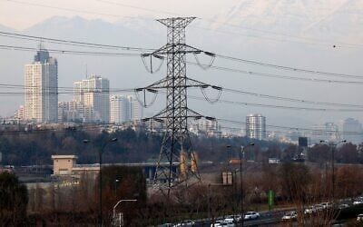 Illustration : La circulation sur une route principale passe devant des pylônes de transmission électrique à Téhéran, le 16 décembre 2024. (Atta Kenare / AFP)