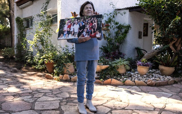 Eva Erban, survivante de la Shoah, tient une photo de famille de ses descendants alors qu'elle pose à son domicile dans la ville d'Ashkelon, dans le sud d'Israël, le 5 décembre 2024.  (Crédit :Menahem Kahana / AFP)