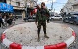 Un membre des forces de sécurité de l'Autorité palestinienne se tient à un rond-point dans le camp de réfugiés de Jénine, dans le nord de la Cisjordanie, le 29 décembre 2024. (Crédit : Jaafar Ashtiyeh/AFP)