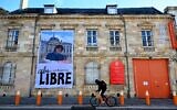 Un cycliste passe devant la Duduchothèque, un espace dédié au travail de Cabu, un designer assassiné il y a dix ans dans un attentat islamiste contre le journal satirique Charlie Hebdo, à Châlons-en-Champagne, dans le nord de la France, le 7 janvier 2025. Douze personnes ont péri dans ces attentats, dont huit membres de la rédaction, tandis qu'une prise d'otages distincte mais liée à celle-ci dans un supermarché juif de l'est de Paris par un troisième tireur le 9 janvier 2015 a fait quatre autres morts. Ce bain de sang a marqué le début d'une période sombre pour la France au cours de laquelle des extrémistes inspirés par Al-Qaïda et le groupe État islamique ont lancé à plusieurs reprises des attentats qui ont mis le pays à rude épreuve et accru les tensions religieuses. (Photo de FRANCOIS NASCIMBENI / AFP)
