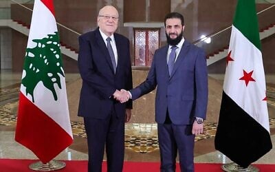 Une photo diffusée par l'agence de presse officielle arabe syrienne (SANA), montre le Premier ministre libanais Najib Mikati, à gauche, serrant la main du nouveau dirigeant syrien Ahmed al-Sharaa avant leur rencontre à Damas le 11 janvier 2025. (Crédit : SANA/AFP)
